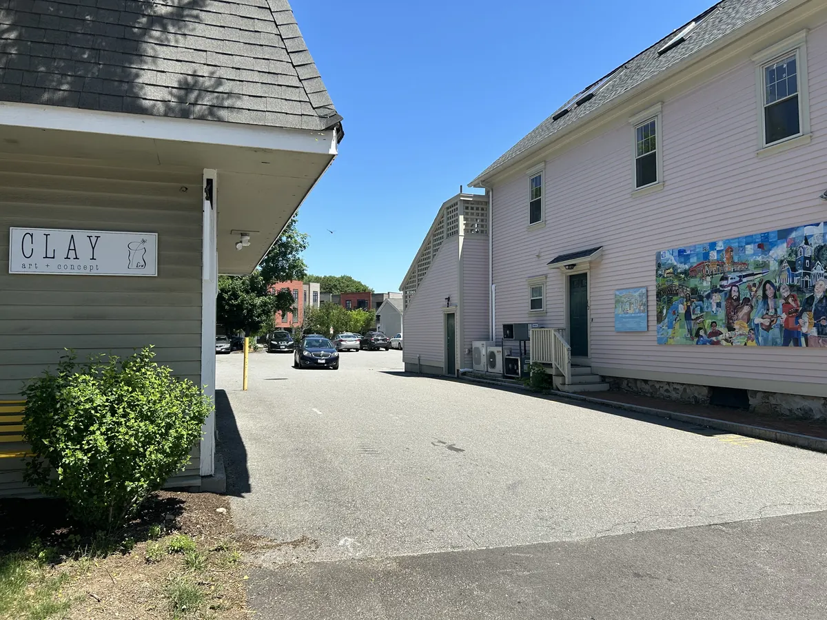 The driveway beside 114 Commonwealth Avenue, with a pink building and a colorful mural